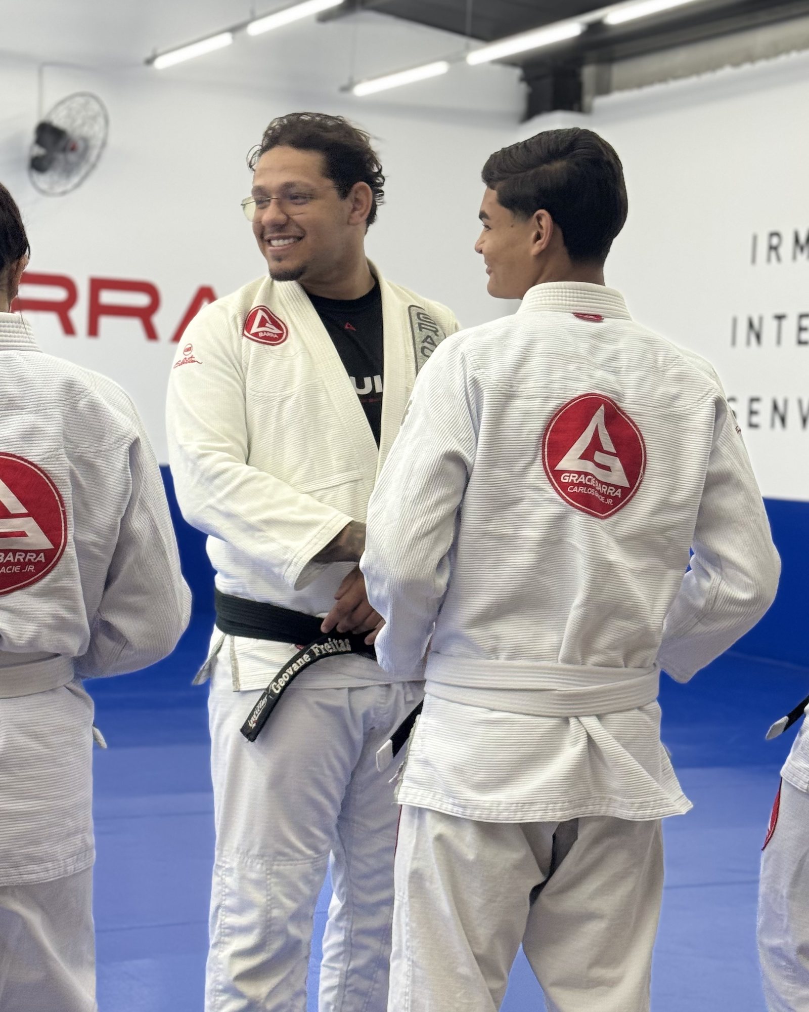 Professor faixa-preta conversando e sorrindo com um aluno antes do treino