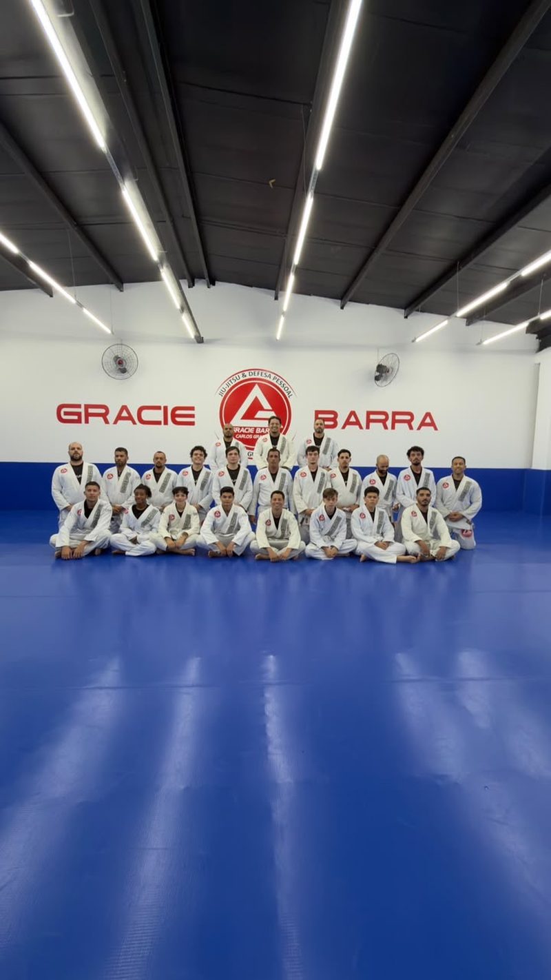 Vista ampla do tatame da academia com a turma ao fundo